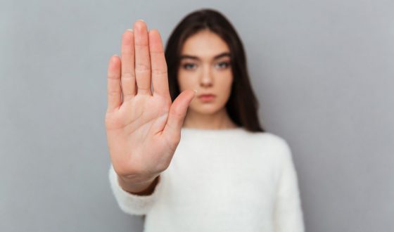 Close up portrait of a woman showing stop gesture